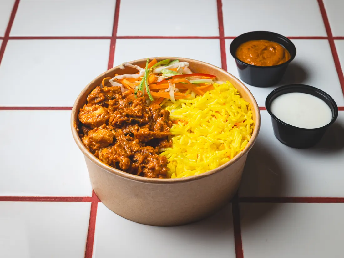 Butter chicken rice bowl with salad, garlic toum and bhuna sauce