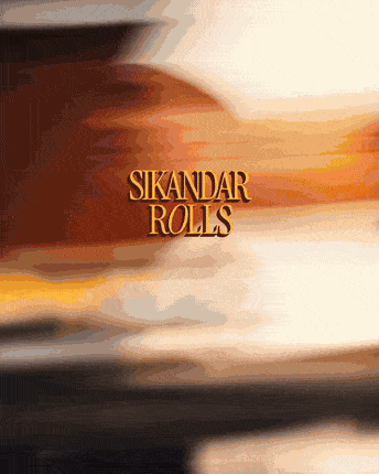A Sikandar roll being made: paratha on the tawa, filling loaded on, rolled and wrapped in the Sikandar paper
